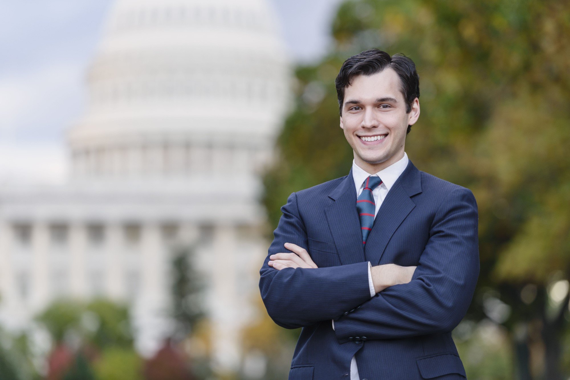 Confident Smiling Man Standing In Front Of US Capitol