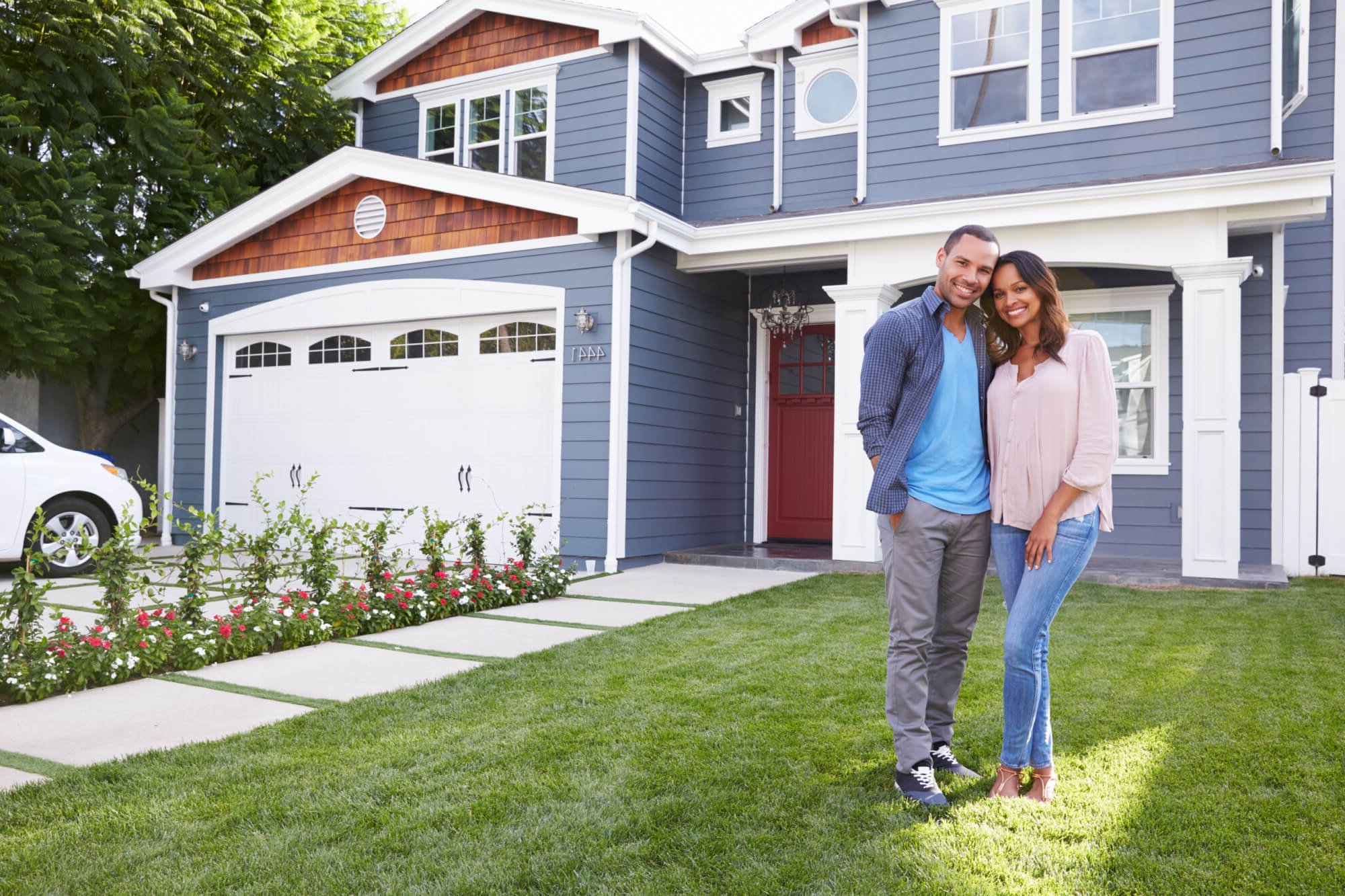 Happy black couple standing outside their house