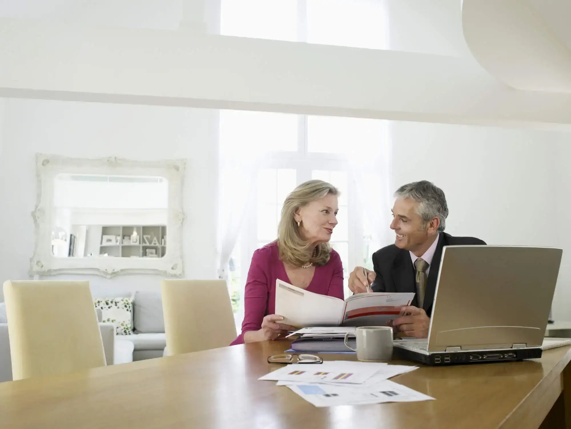 Mature woman sitting at table with financial advisor (1)-1