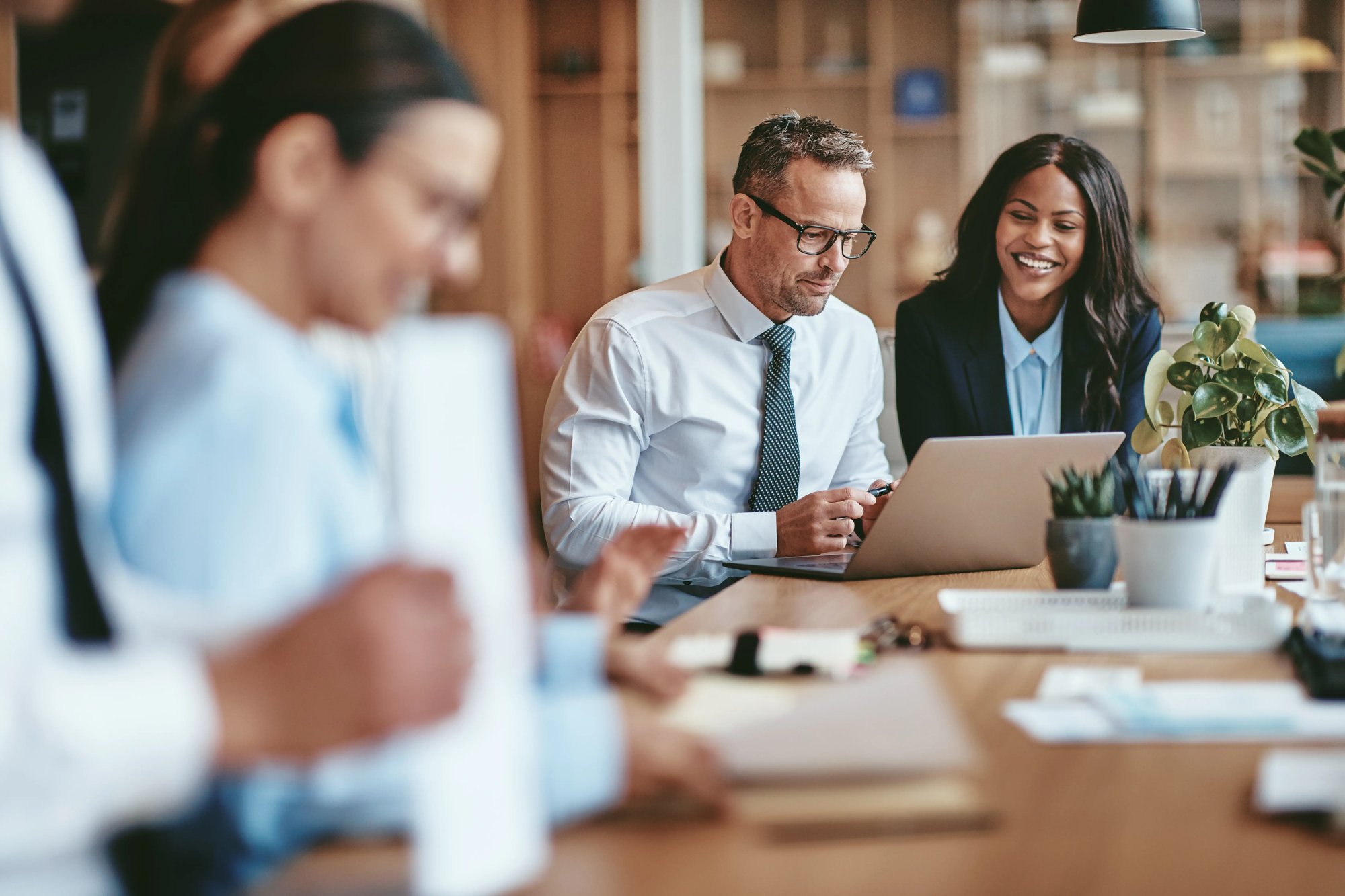 Two diverse businesspeople smiling while working on a laptop together (1)