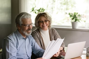 Middle-aged couple looks at insurance documents